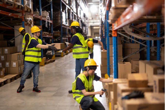 Equipe organizando pedidos e caixas em centro de distribuição para envio